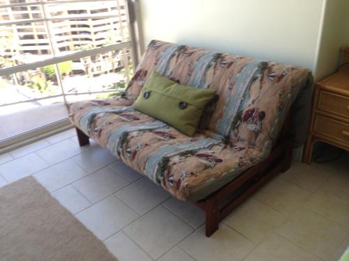 a couch sitting in a room with a window at Waikiki Studio at Ilikai Marina - great apartment by the beach in Honolulu