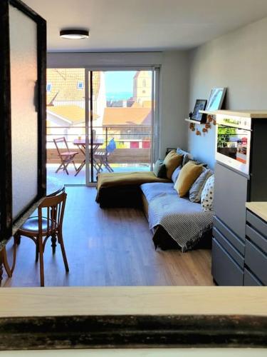 un salon avec un canapé et une table dans l'établissement Appartement au coeur du Village avec terrasse, à Wattwiller