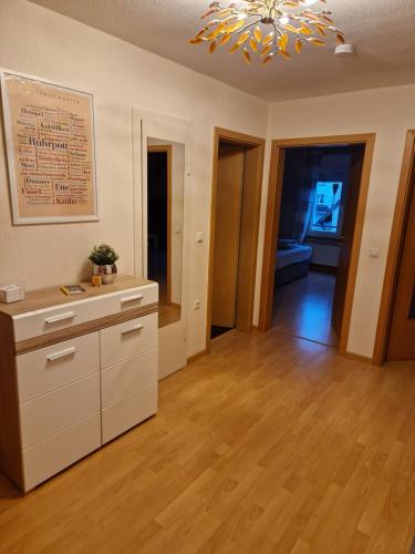 una cocina vacía con lámpara de araña y suelo de madera en Ruhrpottbude - Private Ferienwohnung im Herzen des Ruhrgebiets, en Bochum