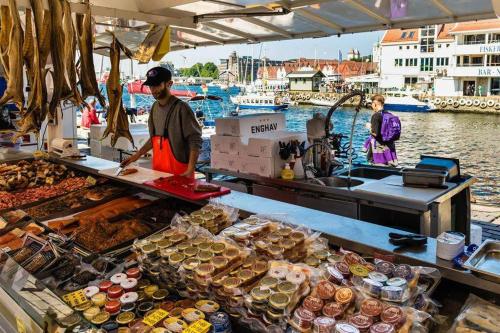 a man preparing food on a boat at a market at Håkonsgaten 11 in Bergen