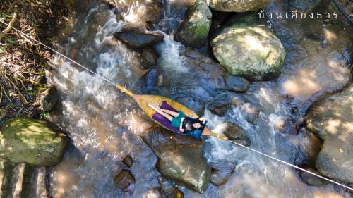 a person in a kayak in a stream at บ้านเคียงธาร โฮมสเตย์ แม่แมะ Cascade Lodge in Amphoe Chiang Dao