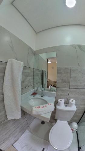 a bathroom with a sink and a toilet and a mirror at Diver Village Ilhabela in Ilhabela