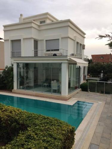 una gran casa blanca con una piscina frente a ella en Private Villa with Pool near Aegean Sea, en Urla