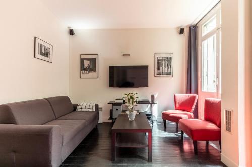 sala de estar con sofá y mesa en Studio sur les quais de Seine en París