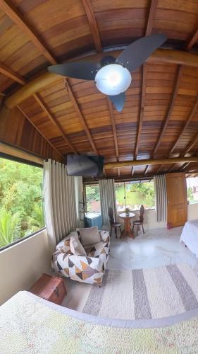 a living room with a ceiling fan and a couch at Diver Village Ilhabela in Ilhabela