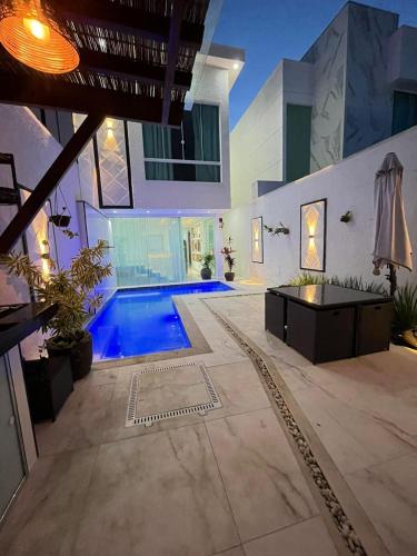 a swimming pool in the middle of a house at Casa Brilho da Lua - 3 Suítes, apenas 300m da Praia in Porto Seguro