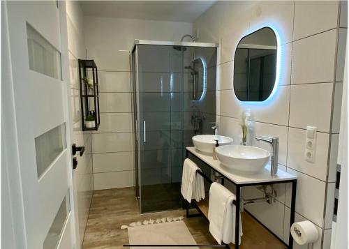 a bathroom with two sinks and a shower with a mirror at Freshly renovated Apartment in Trendy Area! HG21 in Vienna