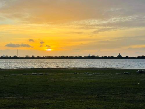 a sunset over a body of water with the sun setting at Four Points Resort - Anuradhapura in Anuradhapura