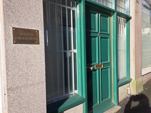 a green door on a building with a sign on it at Lloyds Penthouse in Tavistock