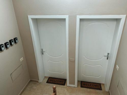 a hallway with two white doors in a room at Clinton Tirana Inn in Tirana