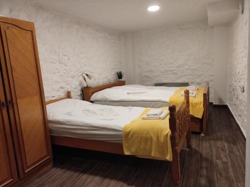 duas camas num pequeno quarto com lençóis amarelos em Old Town Patio House em Ohrid