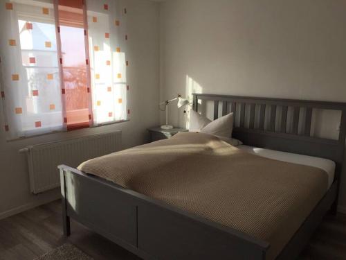 een slaapkamer met een groot bed en een raam bij Apartmentvermietung Ingrid Bolkart - Kirchblick 1 in Illertissen