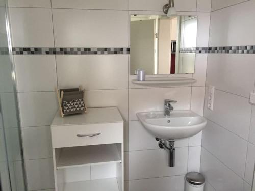 uma casa de banho branca com um lavatório e um espelho em Apartmentvermietung Ingrid Bolkart - Kirchblick 1 em Illertissen
