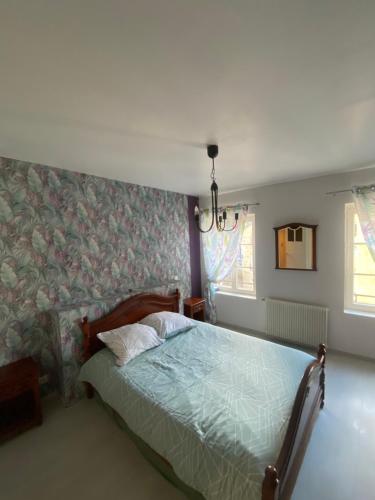 Un dormitorio con una cama con un edredón verde. en Mouss, en Joinville