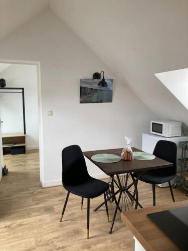 une salle à manger avec une table et deux chaises dans l'établissement LE CLOS DE BEAUCHAMP LE GRENIER DE BEAUCHAMP 3 vélos sont disponibles gratuitement, à Saint-Valery-sur-Somme