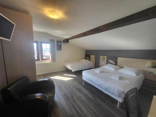 a hotel room with two beds and a chair at Hotel Bellevue in Hendaye