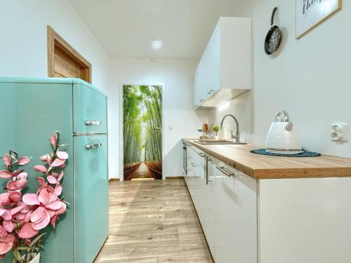 a kitchen with a blue refrigerator and white cabinets at Happiness Holidays - Old Town 10 in Gdańsk