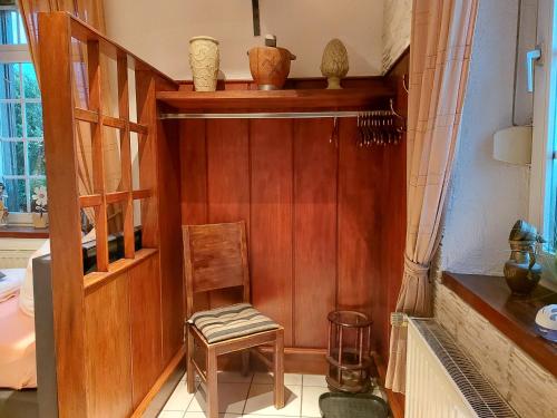 een kamer met een stoel en een houten muur bij Ferienwohnung Villa del Viola Leonardo Apartment in Heinsberg