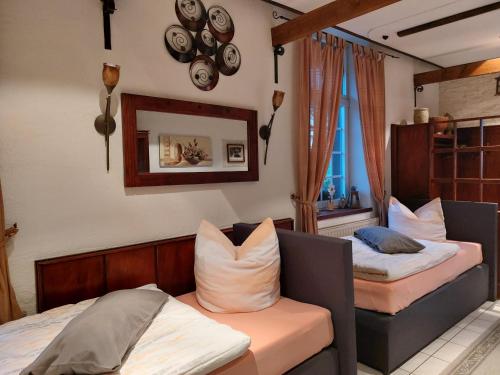een slaapkamer met 2 bedden en een spiegel aan de muur bij Ferienwohnung Villa del Viola Leonardo Apartment in Heinsberg