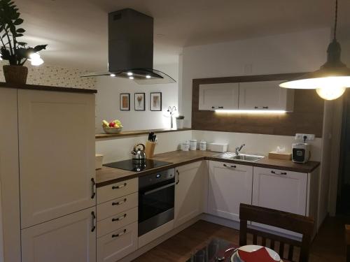 JimramovにあるApartmány Na Staré poštěのキッチン(白いキャビネット、シンク、コンロ付)