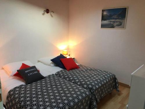 une chambre avec un lit avec des oreillers dessus dans l'établissement Coups de Cœur à Saint Lary maison 4/6 Personnes ***, à Saint-Lary-Soulan