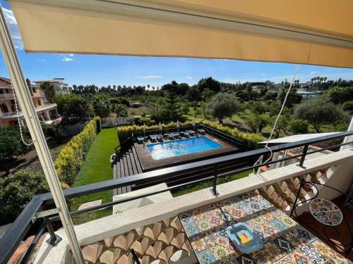 a balcony with a view of a swimming pool at John Sea Suites in Giardini Naxos
