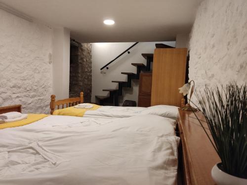 a bedroom with two twin beds and a staircase at Old Town Patio House in Ohrid