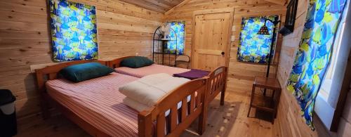 une chambre avec deux lits dans une cabane en rondins dans l'établissement Trent River Cottages, à Hastings