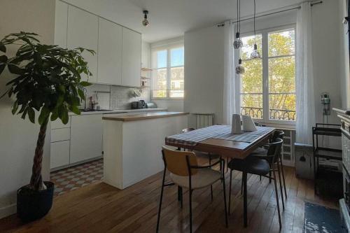 une cuisine avec une table, des chaises et une plante en pot dans l'établissement Luxurious Apartment in Marais, à Paris