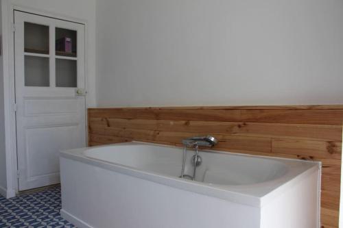 bañera blanca en una habitación con puerta en Gîte de la Madeleine 3*, proche de la Loire, en Gennes