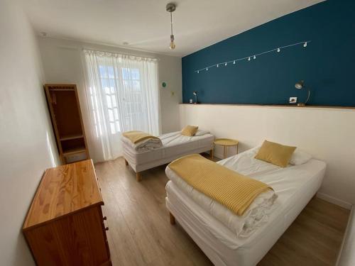 1 dormitorio con 2 camas y pared azul en Gîte de la Madeleine 3*, proche de la Loire, en Gennes