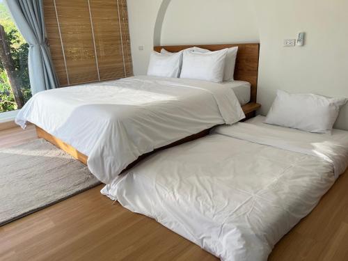 two beds sitting next to each other in a bedroom at Arabica Lodge (อาราบิก้า ลอดจ์) in Ban Huai Khai
