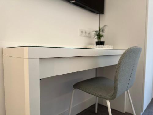 a white desk with a chair in a room at Boutique Hotel GreenLeaf in Sinzing