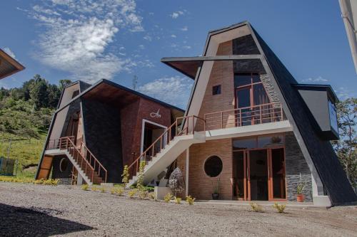 a house with a triangular roof with a staircase at Habitaciones Alpes Oxapampa in Oxapampa