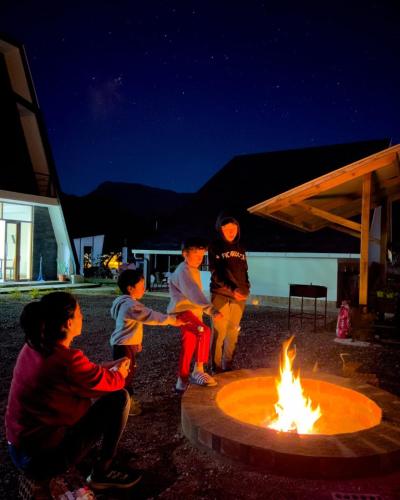 a group of children playing around a fire pit at Habitaciones Alpes Oxapampa in Oxapampa