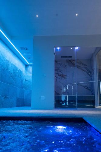 a bathroom with a swimming pool with blue lighting at Casa Nicolini in Barbaresco