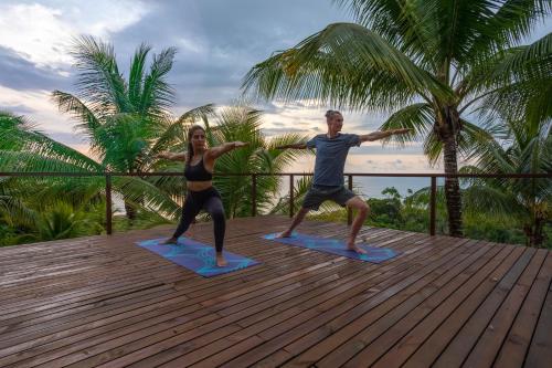 a man and a woman doing yoga on a deck at The Tranquilo Lodge, Adult Only, All meals included in Drake