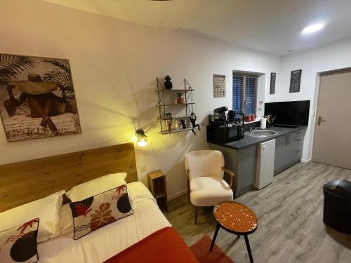 a living room with a couch and a kitchen at Studio du soleil in Saint-Omer