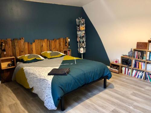 ein Schlafzimmer mit einem Bett und einem Bücherregal in der Unterkunft Comme à la maison in Marsan