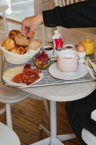 a person holding a tray of breakfast foods on a table at Hotel Edouard VII in Biarritz