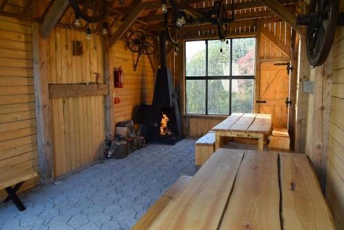 een kamer met 2 houten banken en een open haard bij Osada Dzikie Wino in Budzów