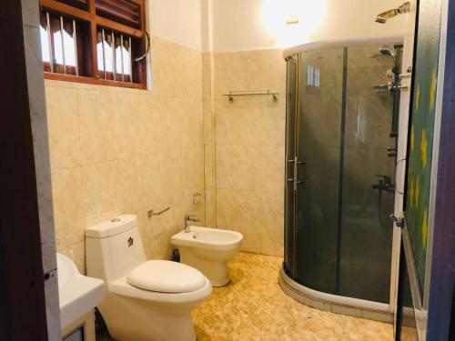 uma casa de banho com um WC e um chuveiro em tashivilla em Maggona West