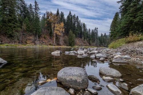 un fiume con rocce e alberi sullo sfondo di Rivers Edge by NW Comfy Cabins a Leavenworth