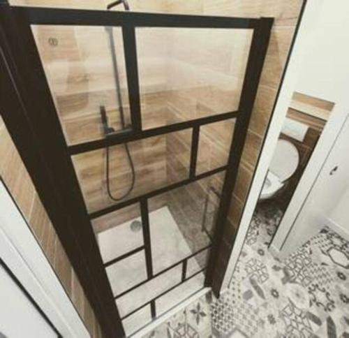 Cette chambre dispose d'une porte en verre et de toilettes. dans l'établissement [Harmonie] proche Gare et Centre ville, à Narbonne