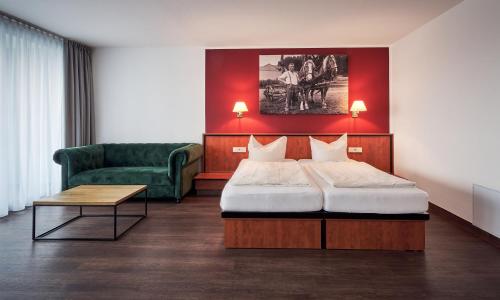 ein Hotelzimmer mit einem Bett und einem Sofa in der Unterkunft MY Parkhotel in Kempten