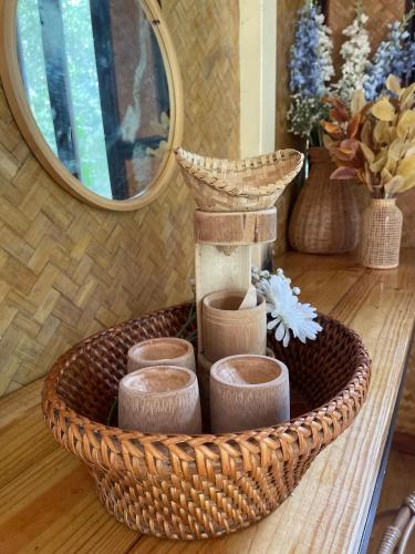 a basket with cups and a mirror on a table at Coffee and Resort in Ko Phayam