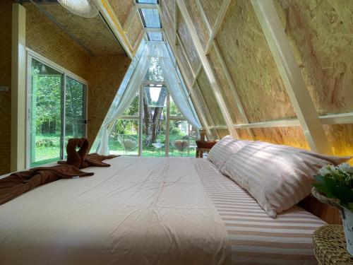 a large bed in a room with a large window at Coffee and Resort in Ko Phayam