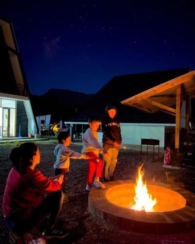 a group of children playing around a fire pit at Habitación Alpes doble independiente in Oxapampa