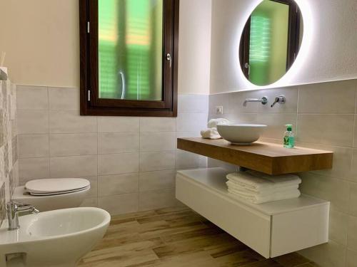 a bathroom with a sink and a toilet and a mirror at Appartamento Relax nelle Vicinanze delle Terme in Monsummano