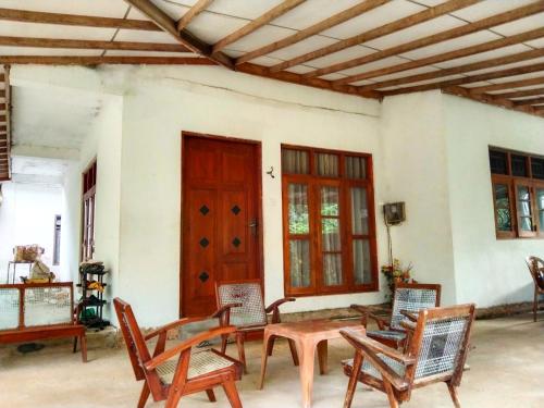 um pátio com cadeiras, uma mesa e uma porta em Villa Charumathi em Matara